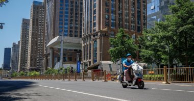 A delivery man travels along an empty road in the central business district of Beijing, China, May 26, 2022. (EPA Photo)