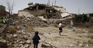 Yemenis pass the rubble of a building destroyed by previous Saudi-led airstrikes on the eve of a renewed truce in Sanaa, Yemen, June 2, 2022. (EPA Photo)