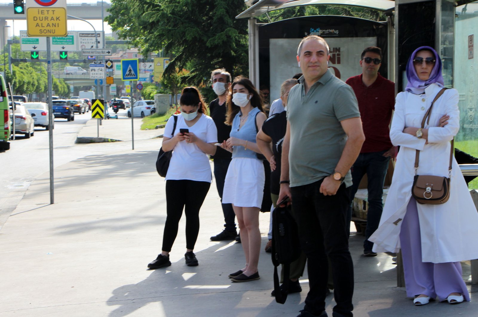 People with and without COVID-19 masks wait at a bus stop, in Istanbul, Turkey, May 30, 2022. (DHA PHOTO) 