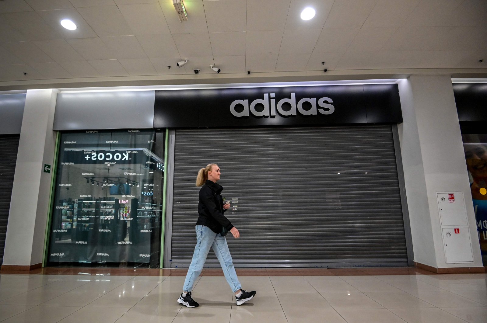 A woman walks past a closed Adidas store at a shopping mall in the town of Chekhov some 75 kilometers (46.6 miles) outside Moscow, Russia, May 27, 2022. (AFP Photo)