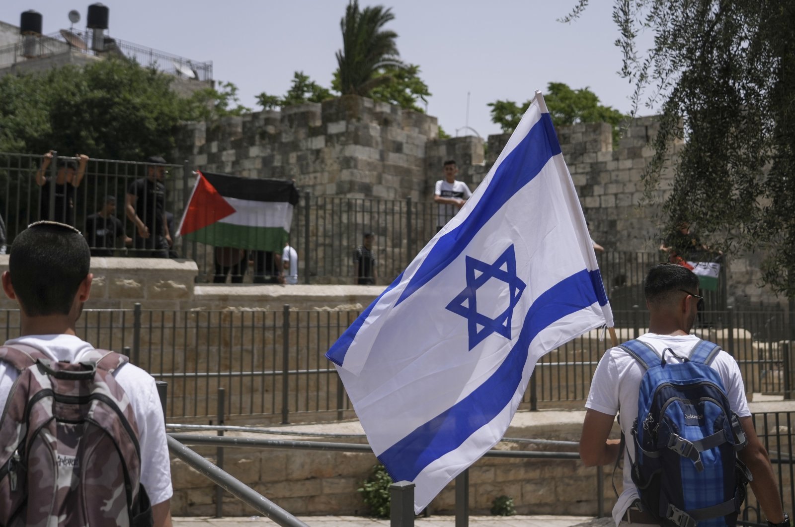 Palestinians and Israelis wave their national flags outside occupied East Jerusalem&#039;s Old City as Israelis mark Jerusalem Day, an Israeli holiday celebrating the capture of the Old City during the 1967 Mideast war, Palestine, May 29, 2022. (AP Photo)
