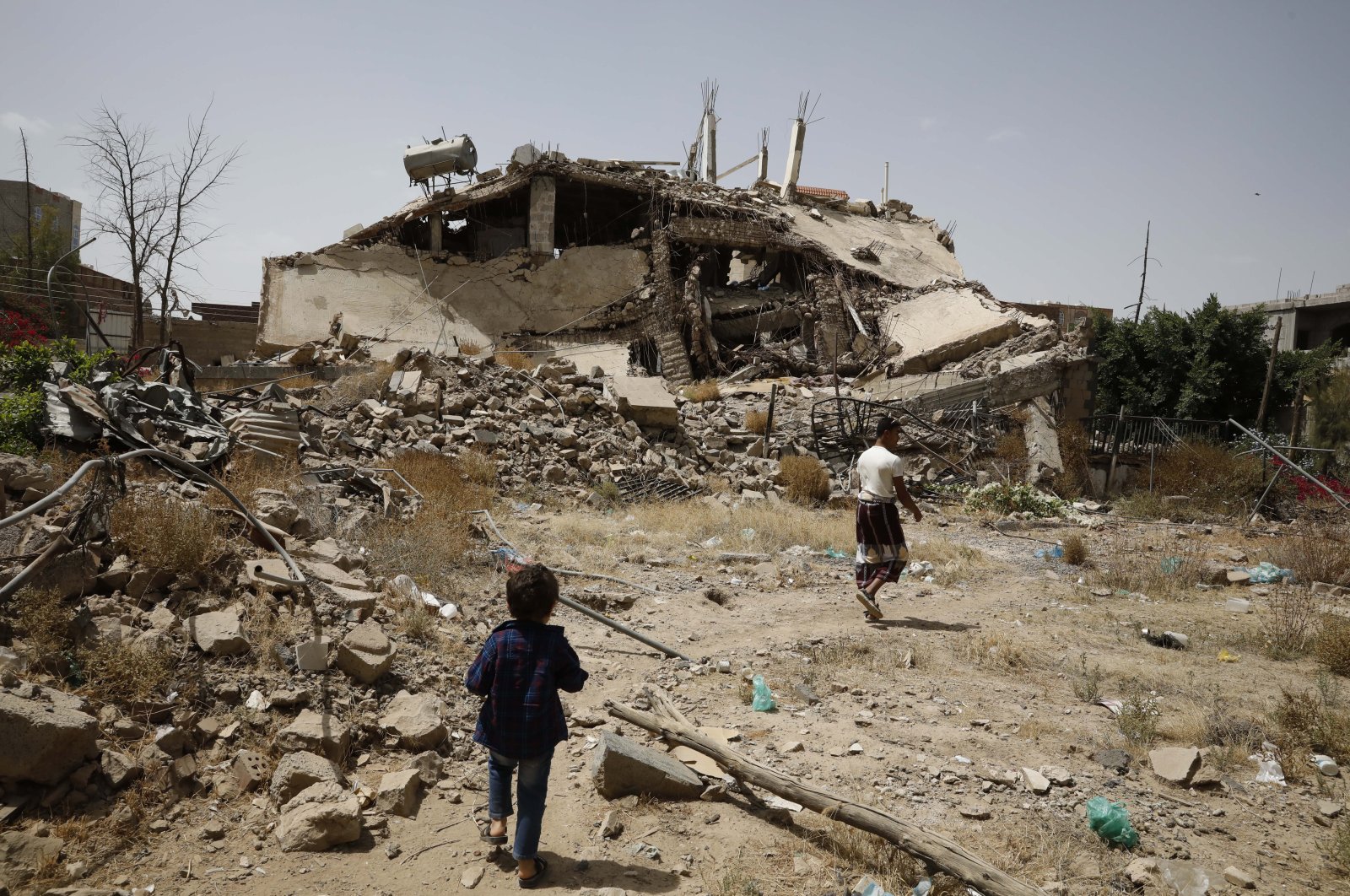 Yemenis pass the rubble of a building destroyed by previous Saudi-led airstrikes on the eve of a renewed truce in Sanaa, Yemen, June 2, 2022. (EPA Photo)
