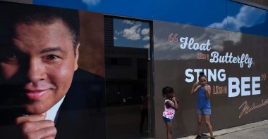 Two girls pose with a photo of Muhammad Ali, in Louisville, Kentucky, U.S., June 7, 2016. (AFP PHOTO)