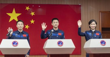 Photo released by Xinhua News Agency, shows Chinese astronauts (L-R) Cai Xuzhe, Chen Dong and Liu Yang, waving as they attend a press conference for the upcoming Shenzhou-14 mission at the Jiuquan Satellite Launch Center, Beijing, China, June 4, 2022. (AP Photo)