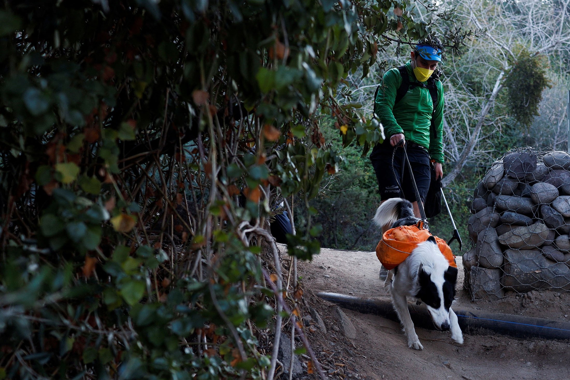 Gonzalo Chiang dan Sam mencari sampah untuk dikumpulkan di taman metropolitan Parquemet di Santiago, Chili, 31 Mei 2022. (Foto Reuters)