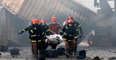 Firefighters carry the dead body of a victim from the site after a fire broke out at a container storage facility in Sitakunda, about 40 kilometers (25 miles) from the key port of Chittagong, Bangladesh, June 5, 2022. (AFP Photo)