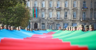 Azerbaijani troops carry a giant flag during a procession marking the anniversary of the end of the 2020 war over Karabakh, in Baku, Azerbaijan, Nov. 8, 2021. (REUTERS Photo)
