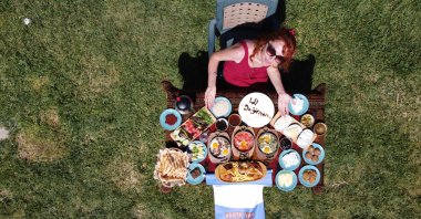 A woman sits behind a traditional Van breakfast table, in Van, eastern Turkey, June 5, 2022. (AA Photo)