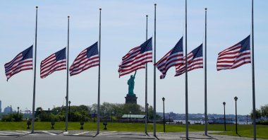 U.S. flags are seen flapping in the wind at half-staff across from the Statue of Liberty, New Jersey, U.S., May 25, 2022. (AFP Photo)