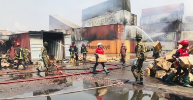 Rescuers try to salvage the remains as smoke continues to come out of containers at the BM Inland Container Depot, where a fire broke out around midnight Saturday in Chittagong, about 210 kilometers (130 miles) southeast of, Dhaka, Bangladesh, June 6, 2022. (AP Photo)