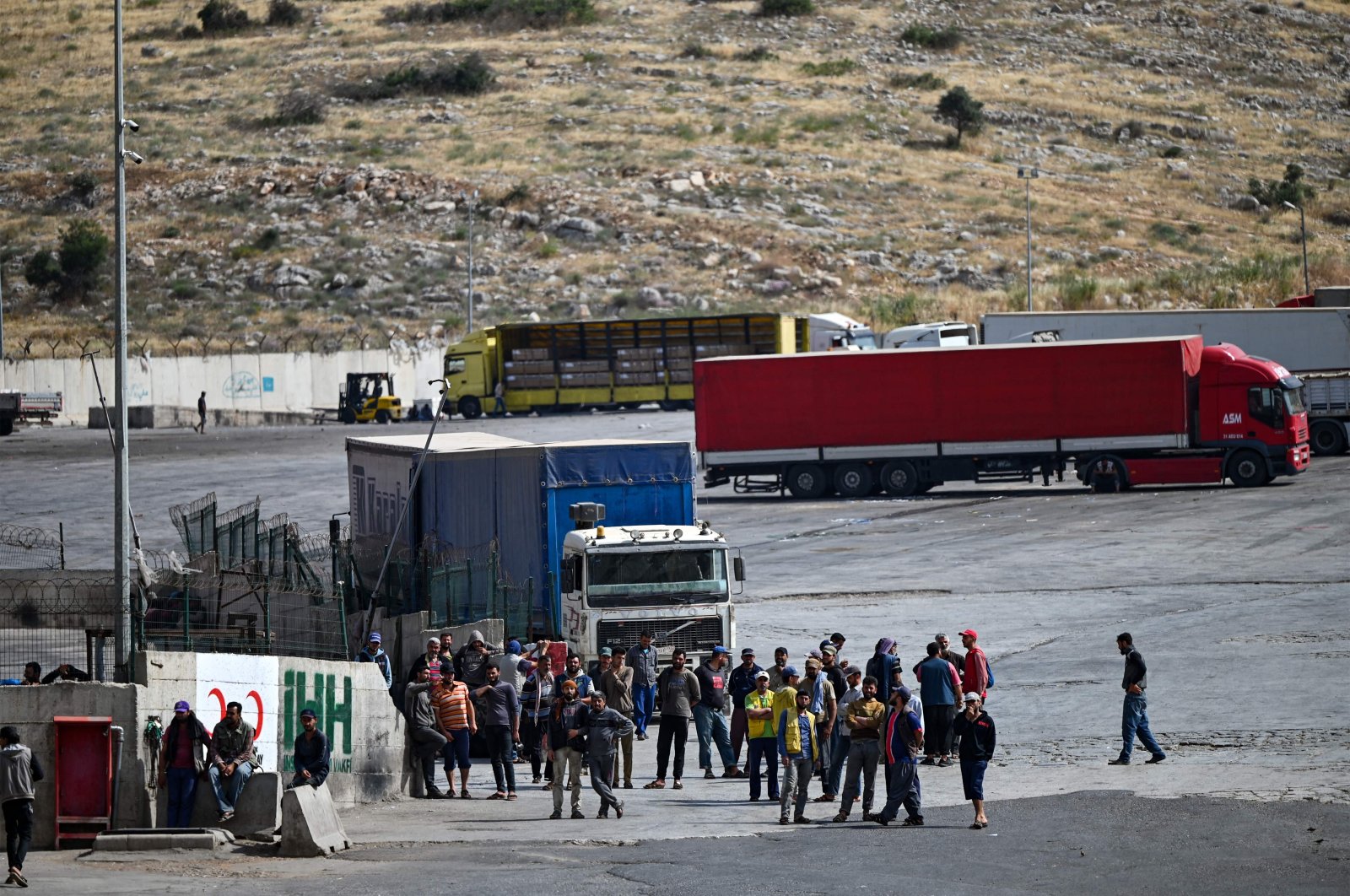 Truck drivers and aid workers wait at the Cilvegözü border gate near the U.N. World Food Programme transfer center in the Reyhanlı district of Hatay, Turkey, June 2, 2022. (Ozan Kose via AFP)
