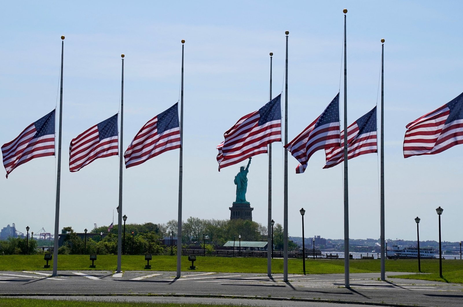 U.S. flags are seen flapping in the wind at half-staff across from the Statue of Liberty, New Jersey, U.S., May 25, 2022. (AFP Photo)