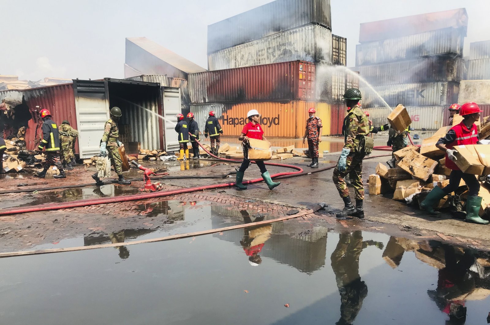Rescuers try to salvage the remains as smoke continues to come out of containers at the BM Inland Container Depot, where a fire broke out around midnight Saturday in Chittagong, about 210 kilometers (130 miles) southeast of, Dhaka, Bangladesh, June 6, 2022. (AP Photo)