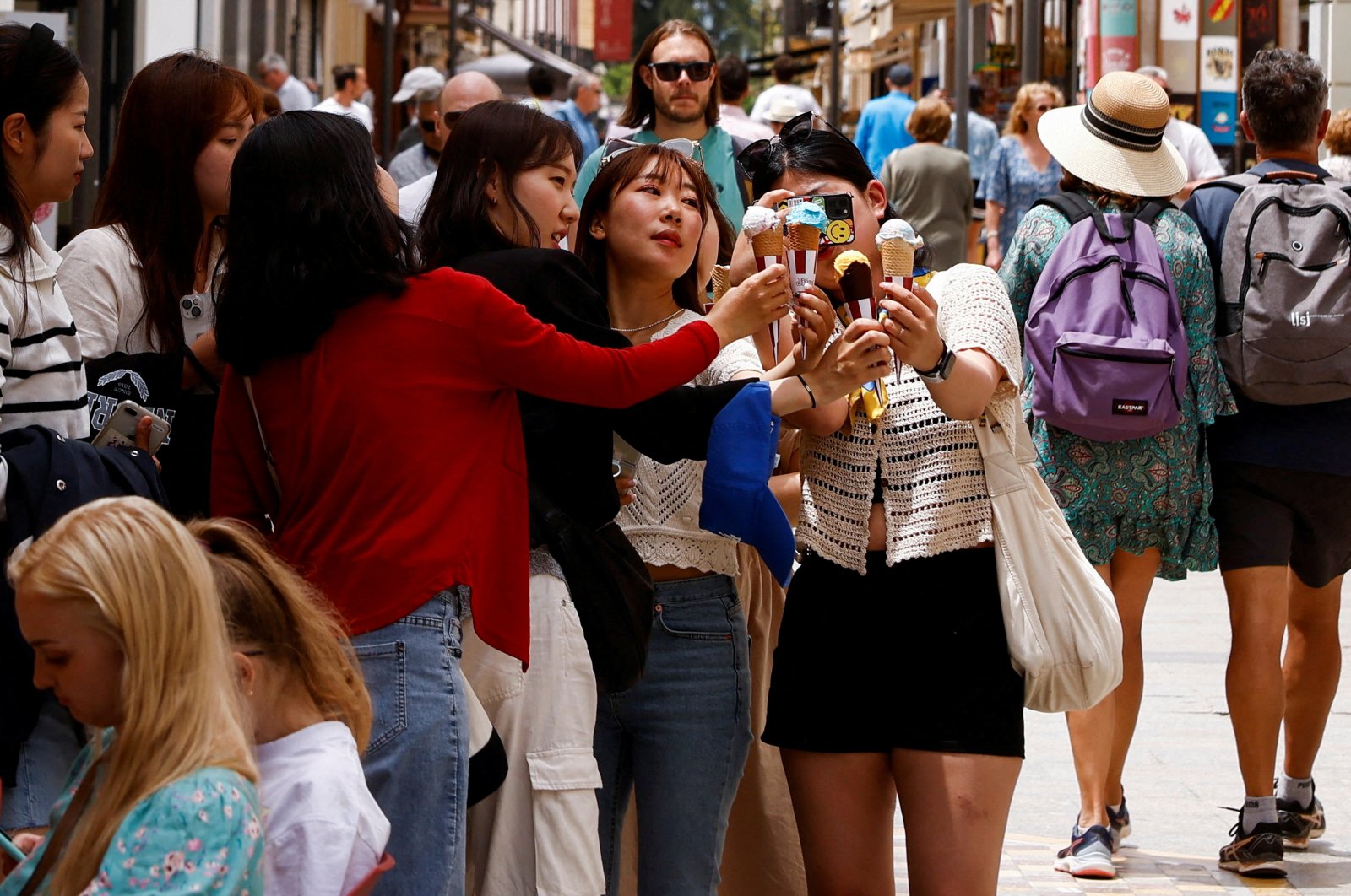 Tourists take a photo of their ice creams as they tour Ronda, Spain, May 25, 2022. (Reuters Photo)