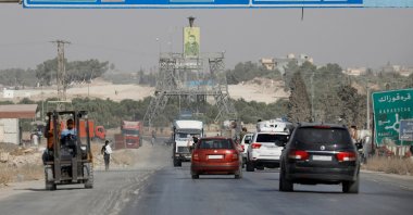 Cars pass under a road sign that shows the direction to Manbij city, at the entrance of Manbij, Syria October 15, 2019. REUTERS/Omar Sanadiki/File Photo