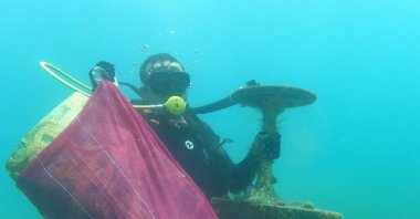 A diver carries the garbage he collected off the coast of Bodrum, Muğla, southwestern Turkey, June 8, 2022. (İHA PHOTO)