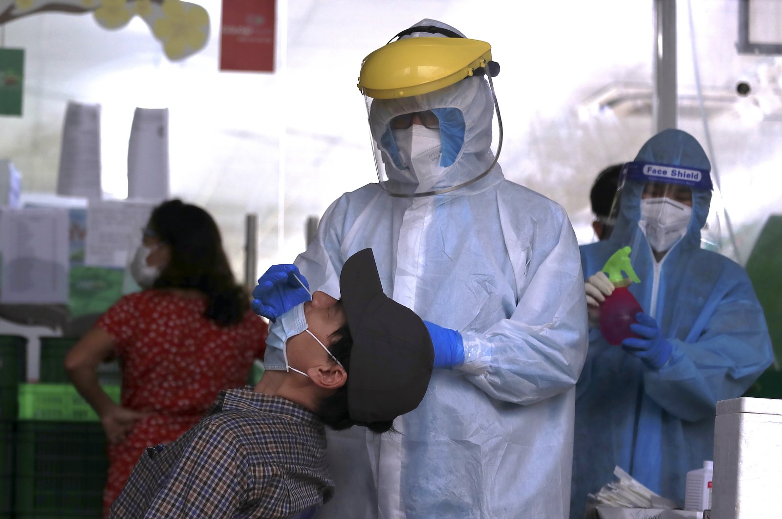 A health worker takes a sample from a man for a COVID-19 test in Hanoi, Vietnam, Jan. 6, 2022. (AP Photo)