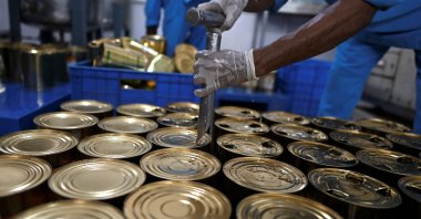 A worker opens tins of ingredients during the production of the Rooh Afza beverage at the Hamdard Laboratories factory in Manesar, India, May 21, 2022. (AFP Photo)