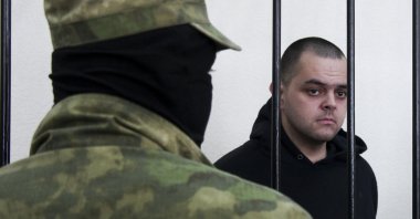 British citizen Aiden Aslin stands behind bars in a courtroom in Donetsk, eastern Ukraine, June 9, 2022. (AP Photo)