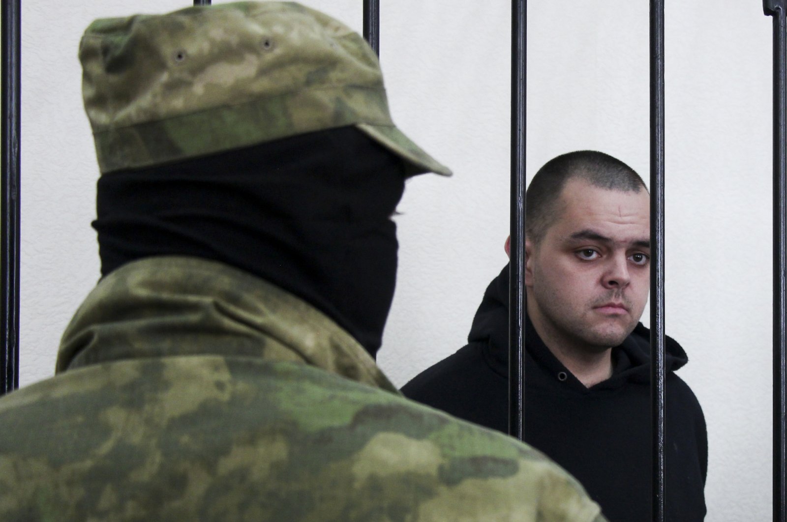 British citizen Aiden Aslin stands behind bars in a courtroom in Donetsk, eastern Ukraine, June 9, 2022. (AP Photo)