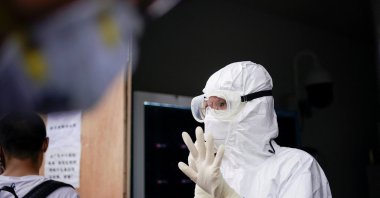 A health care professional gestures as residents line up for nucleic acid tests in Wuhan, the Chinese city hit hardest by the COVID-19 outbreak, Hubei province, China, May 16, 2020. (Reuters Photo)