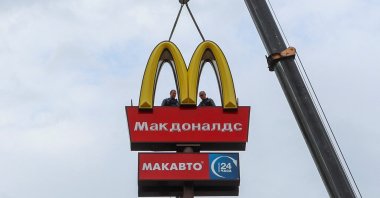 Workers use a crane to dismantle the McDonald's Golden Arches while removing the logo signage from a drive-through restaurant of McDonald's in the town of Kingisepp in the Leningrad region, Russia June 8, 2022. (Reuters Photo)