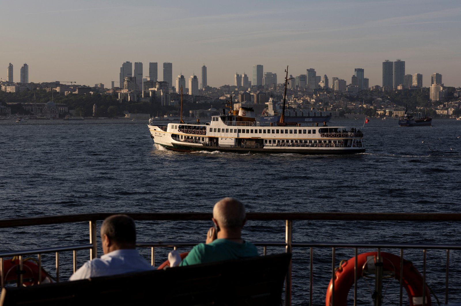 Commuters enjoy a sunny afternoon on board of a ferry as another one sails in the Bosporus in Istanbul, Turkey, May 27, 2022. (Reuters Photo)