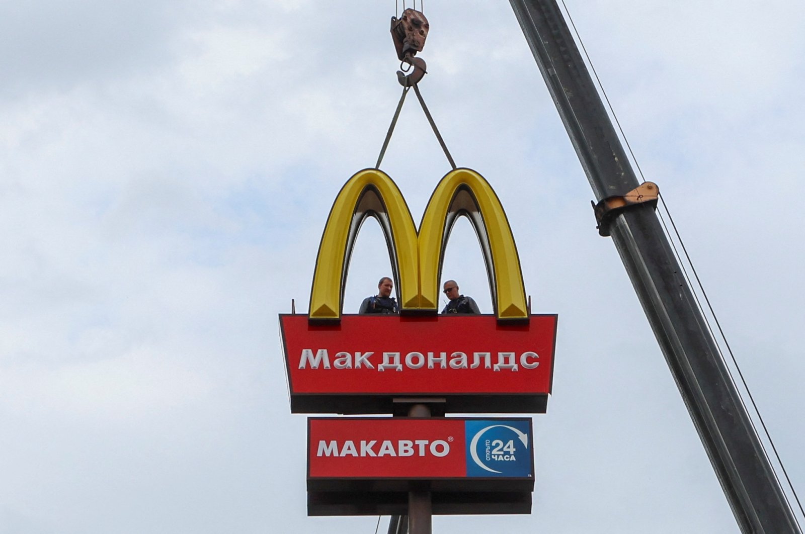Workers use a crane to dismantle the McDonald&#039;s Golden Arches while removing the logo signage from a drive-through restaurant of McDonald&#039;s in the town of Kingisepp in the Leningrad region, Russia June 8, 2022. (Reuters Photo)
