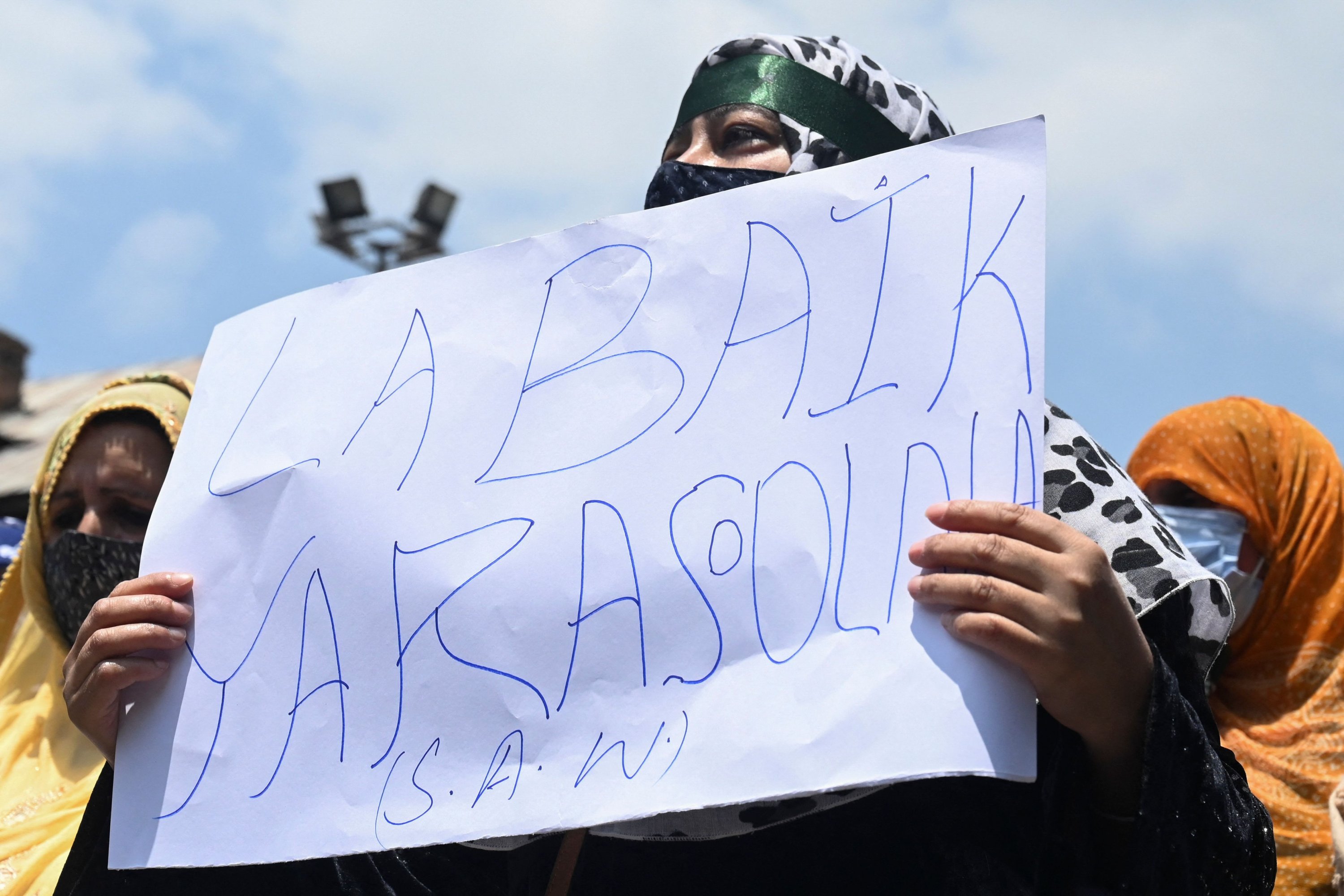 A Kashmiri woman shouts Islamic slogans and holds a placard during a protest against India's Bharatiya Janata Party former spokesperson Nupur Sharma over her remarks about Prophet Muhammad, Srinagar, India-administered Kashmir, June 11, 2022. (AFP Photo)