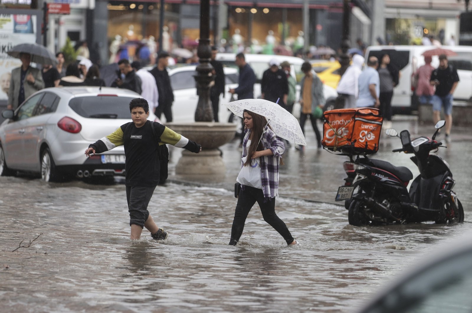 People try to cross a flooded street in Ankara, Turkey, June 11, 2022. (AA Photo)