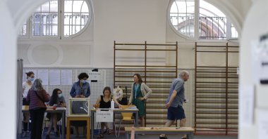A man leaves the voting station while municipal volunteers wait for voters in Strasbourg, eastern France, June 12, 2022. (AP Photo)