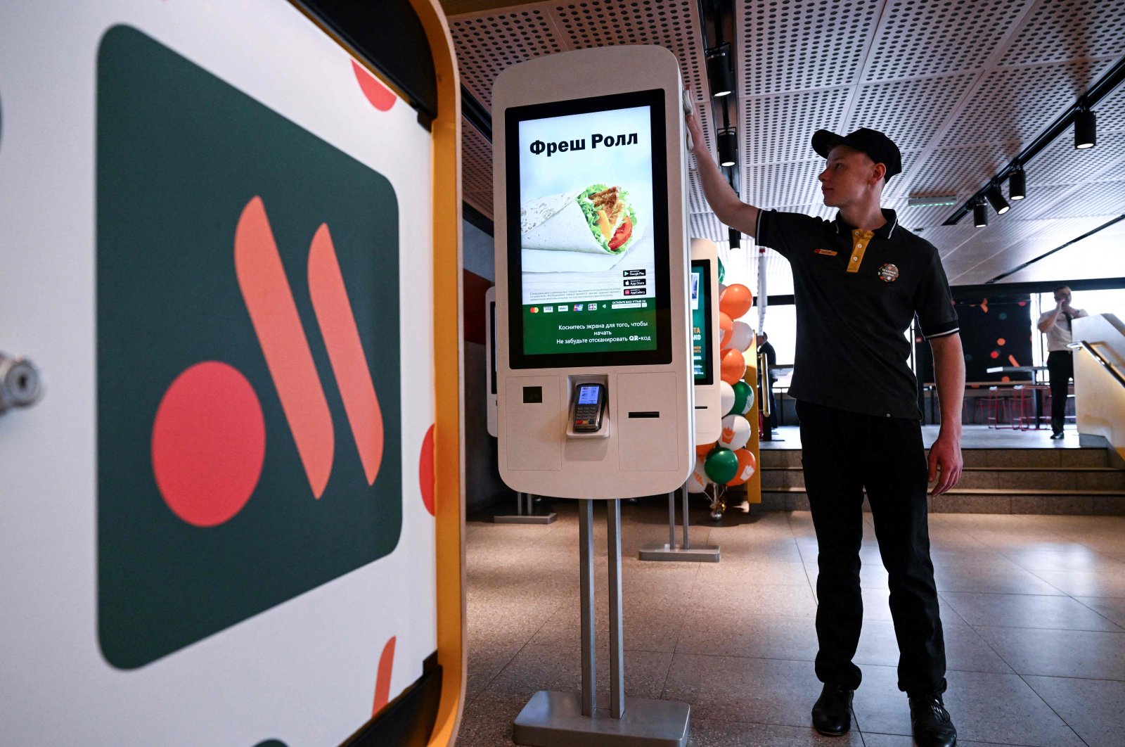 An employee cleans a self-ordering machine at the Russian version of a former McDonald&#039;s restaurant before the opening ceremony, Moscow, Russia, June 12, 2022. (AFP Photo)