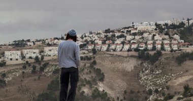 A Jewish settler looks at the West Bank settlement of Maaleh Adumim, from the E-1 area on the eastern outskirts of Jerusalem, occupied Palestine, Dec. 5, 2012. (AP Photo)