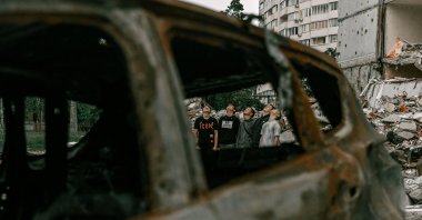 Students pose outside a damaged building for a high school graduation photoshoot, as Russia's attack on Ukraine continues, in Chernihiv, Ukraine, June 5, 2022. (Instagram of @senykstas via Reuters)