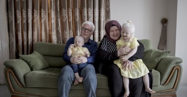 Sefa (R) and Hikmet Emdi, pose with their children in their home in Istanbul, Turkey, June 13, 2022. (AA PHOTO)
