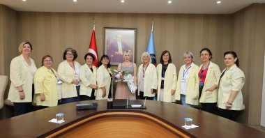 "Yellow Angels" pose with Akdeniz University rector Özlenen Özkan (C), in Antalya, southern Turkey, June 11, 2022. (AA PHOTO)
