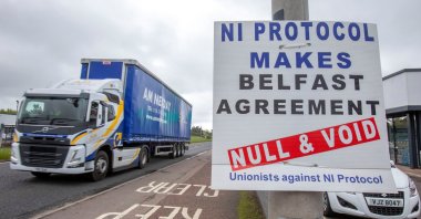 A lorry passes an anti "Northern Ireland Protocol" sign as it is driven away from Larne port, north of Belfast in Northern Ireland, after arriving on a ferry, May 17, 2022. (AFP Photo)