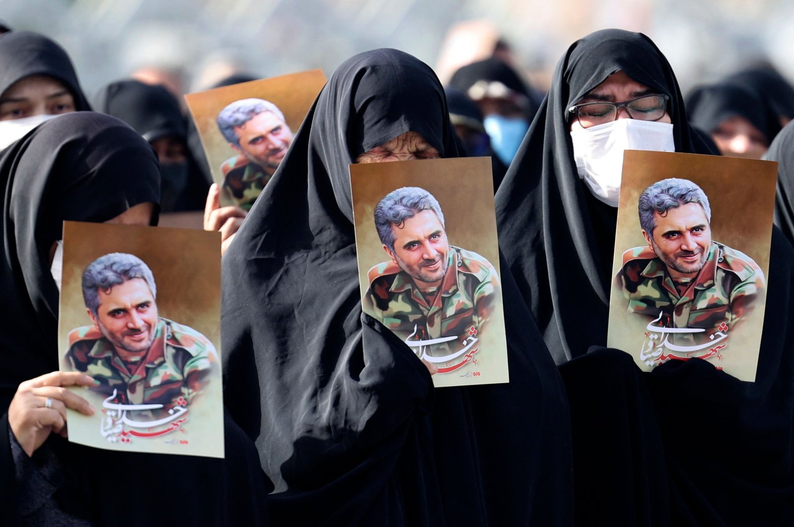 Iranian women lift portraits of Revolutionary Guards Col. Hassan Sayad Khodayari during his funeral procession at Imam Hussein Square, Tehran, Iran, May 24, 2022. (AFP Photo)