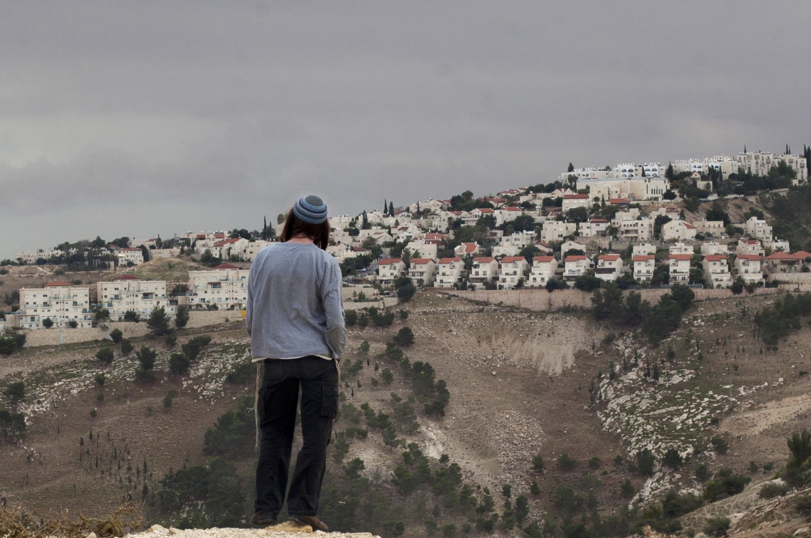 A Jewish settler looks at the West Bank settlement of Maaleh Adumim, from the E-1 area on the eastern outskirts of Jerusalem, occupied Palestine, Dec. 5, 2012. (AP Photo)