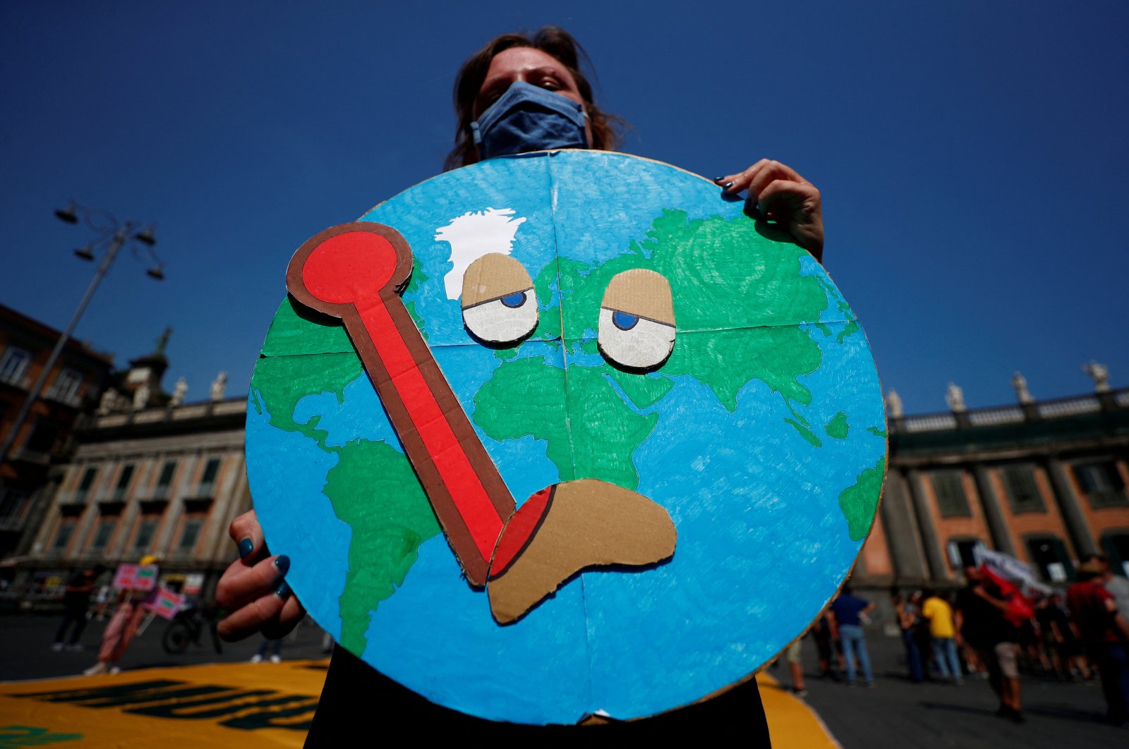 A person holds a placard as climate activists including Extinction Rebellion and Fridays for Future stage a protest demanding more action whilst G-20 climate and environment ministers hold a meeting in Naples, Italy, July 22, 2021. (Reuters Photo)