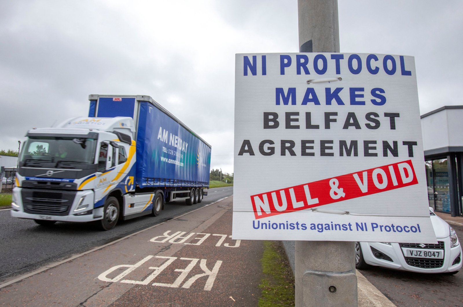 A lorry passes an anti &quot;Northern Ireland Protocol&quot; sign as it is driven away from Larne port, north of Belfast in Northern Ireland, after arriving on a ferry, May 17, 2022. (AFP Photo)