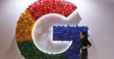A woman walks past the logo for Google at the China International Import Expo, Shanghai, China, Nov. 5, 2018. (AP Photo)