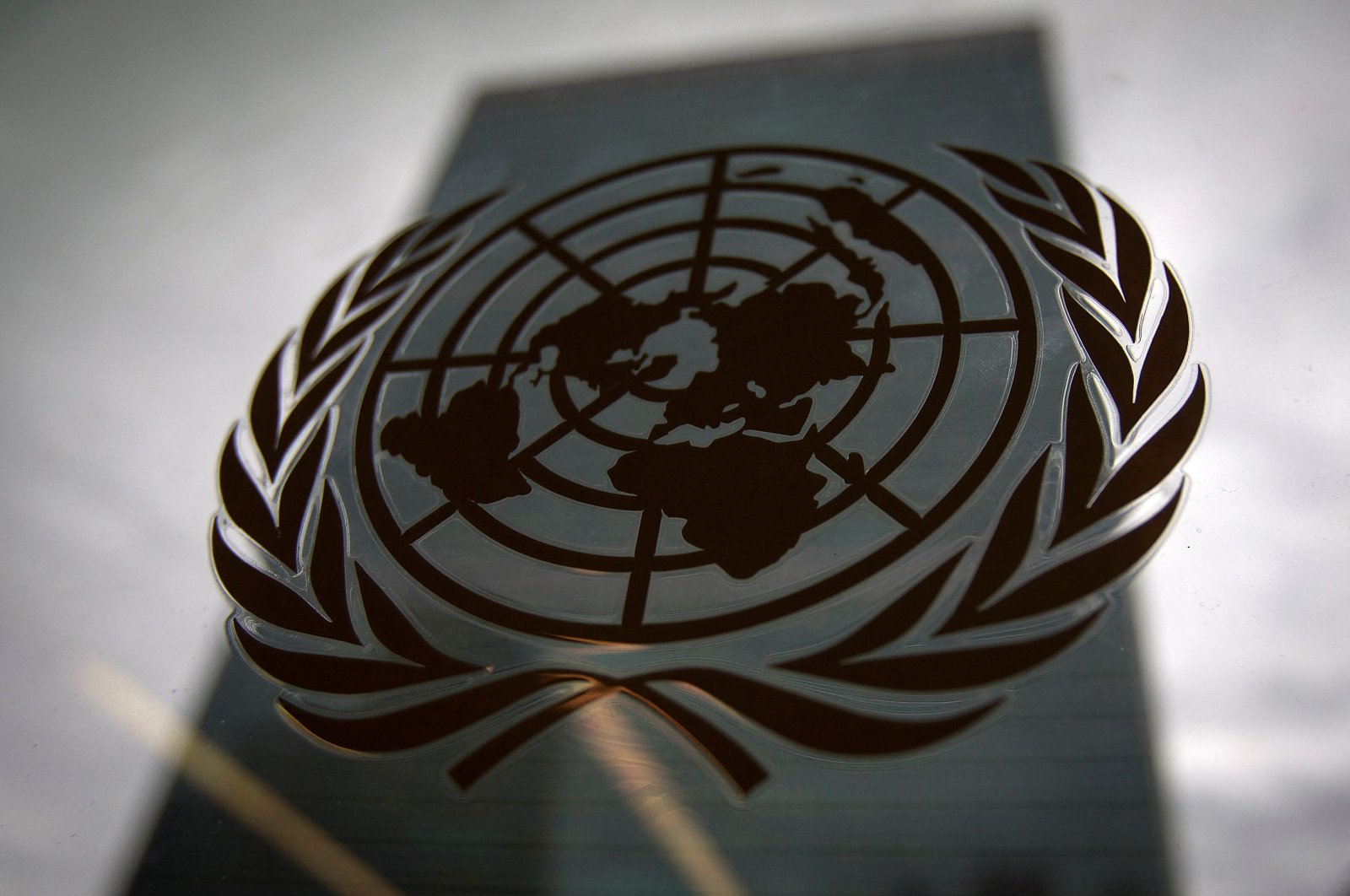 The United Nations headquarters building is pictured through a window with the U.N. logo in the foreground in the Manhattan borough of New York, U.S., Aug. 15, 2014. (Reuters Photo)