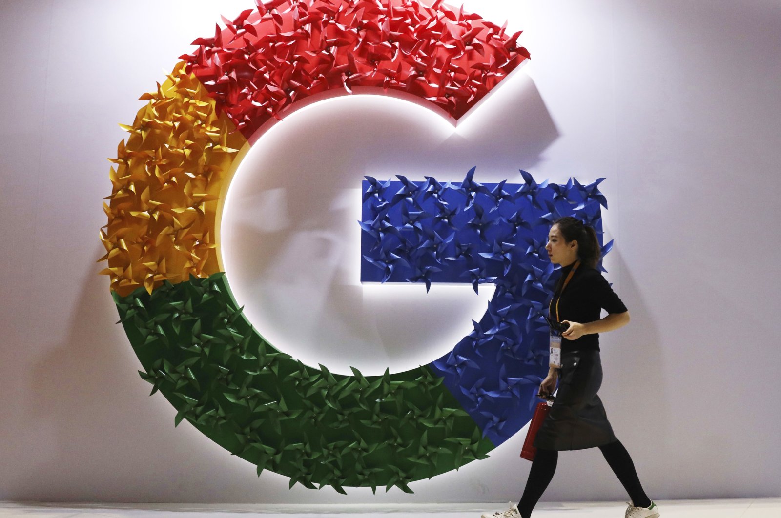 A woman walks past the logo for Google at the China International Import Expo, Shanghai, China, Nov. 5, 2018. (AP Photo)