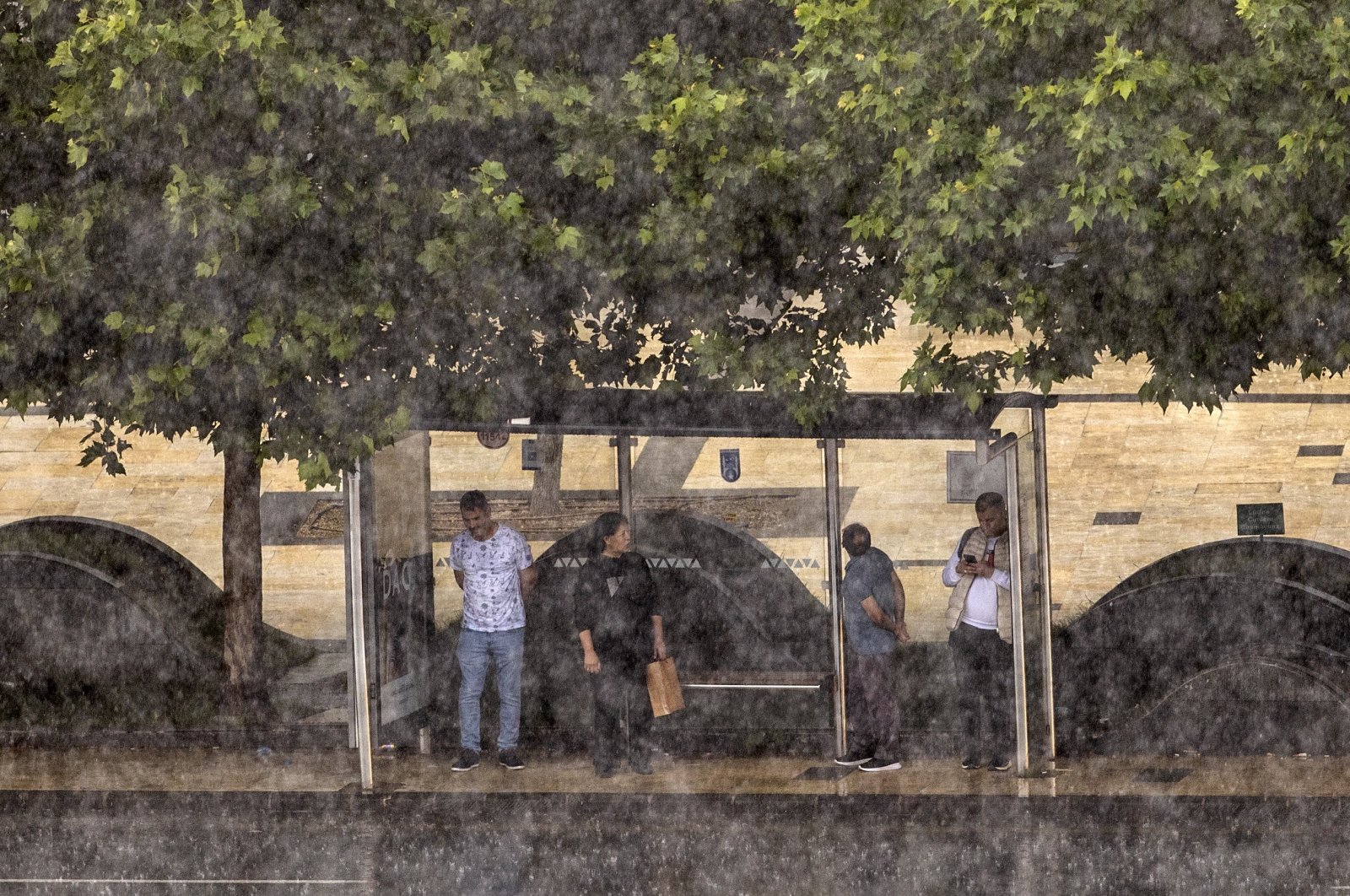 People wait at a bus stop amid a downpour, in the capital Ankara, Turkey, June 14, 2022. (AA Photo)