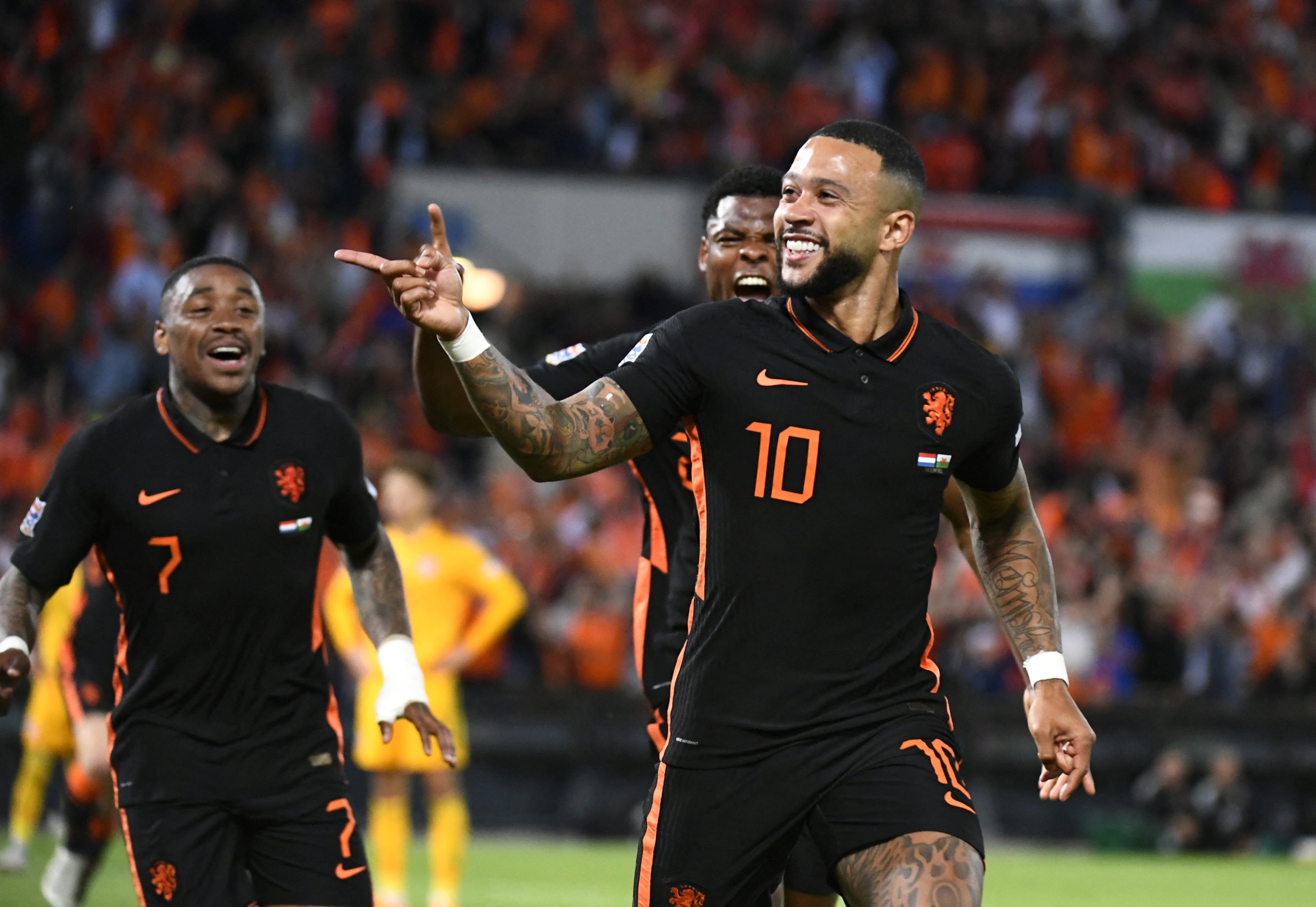 Memphis Depay (kanan) dari Belanda merayakan dengan rekan setimnya setelah mencetak gol ke gawang Wales dalam pertandingan UEFA Nations League, Rotterdam, Belanda, 14 Juni 2022. (Foto Reuters)