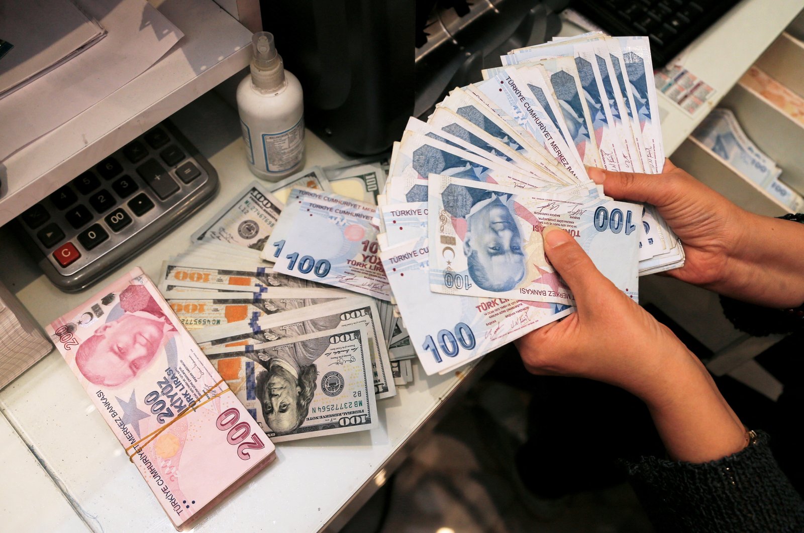 A money changer holds Turkish lira banknotes at a currency exchange office in Ankara, Turkey, Oct. 12, 2021. (Reuters Photo)