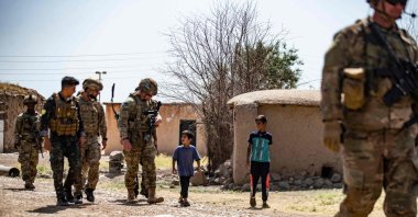 American soldiers patrol a village in the countryside of the Kurdish-majority city of Qamishli, northeastern Hassakeh province, Syria, June 12, 2022. (AFP Photo)