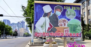 A sign depicting a scene of medical products transportation is displayed at the empty street, amid growing fears over the spread of COVID-19, Pyongyang, North Korea, May 23, 2022. (Kyodo via Reuters)