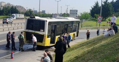 Passengers wait on the roadside after a bus broke down in the Kartal district, in Istanbul, Turkey, May 30, 2022. (AA PHOTO)